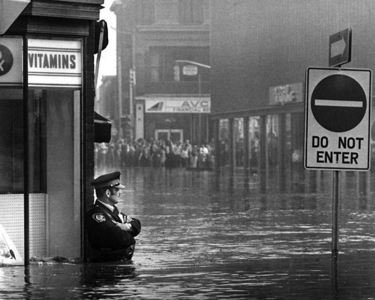 Police Officer Guarding Pharmacy During Flood